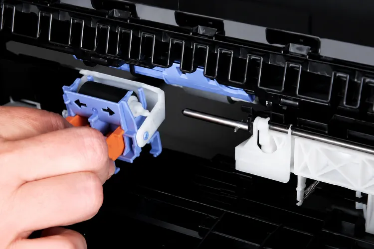 Technician inspecting tray feed rollers during HP Laserjet M607 M608 M609 Printer Repair